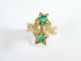 a close up of a gold ring with a green stone and diamonds