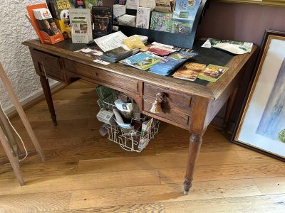 a desk with a suitcase on top of it next to a painting