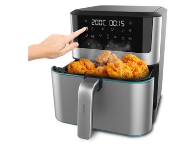 une friteuse à air chaud contenant du poulet frit, avec une main qui la désigne