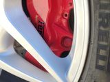 a close up of a red brake on a white car