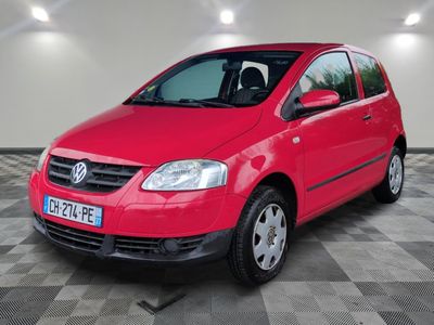 la voiture rouge est garée dans le garage sur le sol en damier