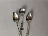 three spoons and a spoon rest on a white surface