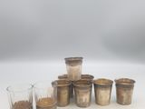 six tasses de café sont alignées les unes à côté des autres sur une surface blanche