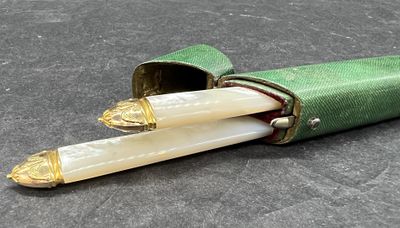 un étui vert contenant deux bougies blanches