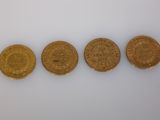 four different types of gold coins on a white surface