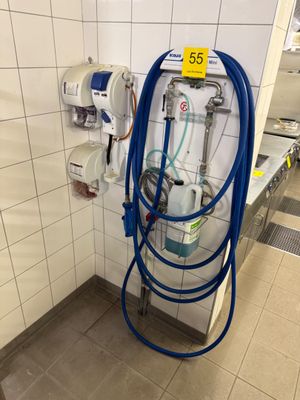 un tuyau bleu fixé au mur dans des toilettes publiques