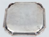 a silver tray with a handle on a white surface