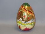 a golden egg with a bird on it sitting on a table
