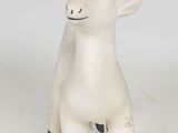 a small white animal statue on a white surface