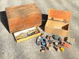 a wooden box filled with assorted items sitting on the ground