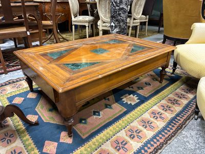 une table basse avec un plateau en verre posée sur un tapis