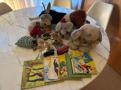 many stuffed animals sitting on a table with books on it