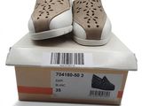 une paire de chaussures dans une boîte posée sur une surface blanche, avec un code-barres