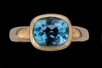 une image représentant une bague en or sertie d'une topaze bleue