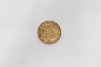 a close up of a gold coin on a white surface