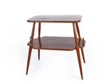La table d'appoint est en bois et comporte deux étagères de chaque côté.