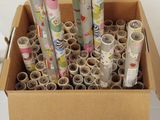 de nombreux rouleaux de papier dans une boîte en carton posée par terre