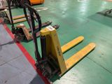 a yellow forklift sitting on the floor in a warehouse