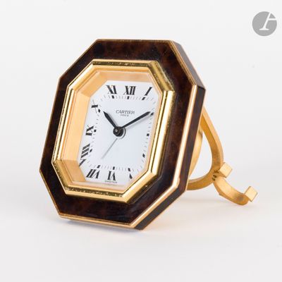 une horloge posée sur un support sur une table