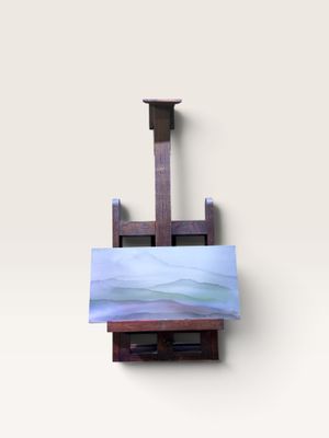 un petit chevalet sur lequel est posé un tableau, posé sur une surface blanche