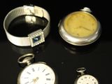three different types of pocket watches on a table with a black background