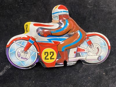 a toy motorcycle with a man on it on a black surface