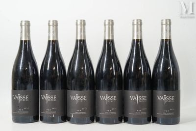 six bouteilles de vin sont alignées sur une table