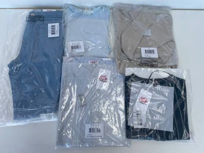 plusieurs paires de t-shirts pour hommes emballés dans du plastique, posés sur une table