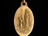 an image of a gold medal with the image of the virgin and child on it