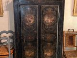 un meuble à porte et une table sur laquelle est posé un vase