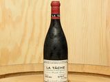 a bottle of wine sitting on top of a barrel