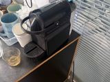 une cafetière noire posée sur une table en bois