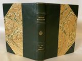 un livre noir et or posé sur une table blanche