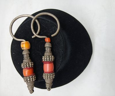 deux paires de boucles d'oreilles qui se trouvent sur un chapeau noir