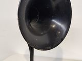 an old black phonom on a table with a cord