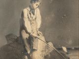une vieille photo d'un homme assis au sommet d'un tas de sable