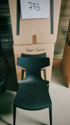 une chaise noire posée devant une pile de cartons