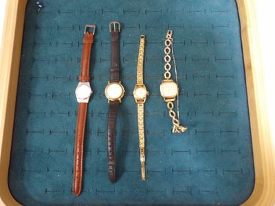 trois montres et deux bracelets exposés dans une vitrine