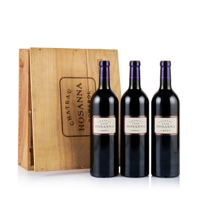trois bouteilles de vin devant une caisse en bois