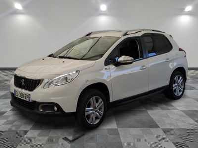 la voiture blanche est garée sur un sol en damier dans le garage