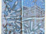 un gros plan sur une écharpe ornée d'une image représentant une maison dans la neige