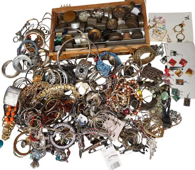 a wooden box full of assorted jewelry on a white surface