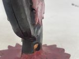 statue of a person with a broken leg on a red flower