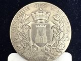 un gros plan d'une pièce d'argent sur laquelle figure un blason