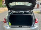the back of a silver car with its trunk open on the road