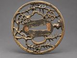 a bronze plate with a bird and flowers on it