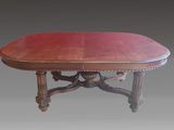 une table à manger ovale avec un plateau rouge et des pieds sculptés