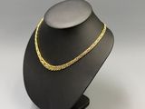 a black mannequin with a gold chain on it