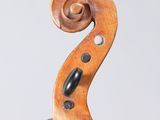 a close up of the back of a violin with a fiddle in the foreground