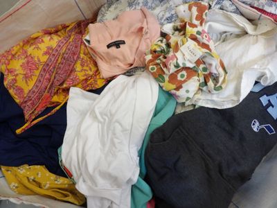 a suitcase full of clothes that is sitting on the floor